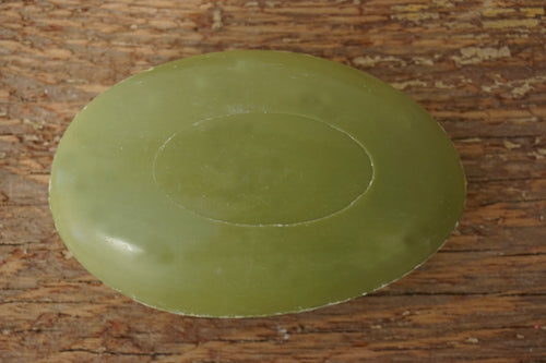 Tvål formad som gåsägg. Tryckt text på ovansidan. Mörkare grön färg, doft av ren oliv.