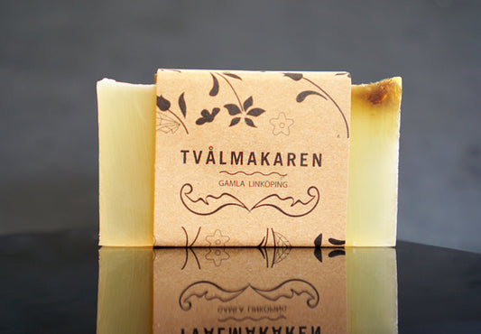 Ekologisk Handgjord tvål. Rektangulärgformad och inslagen i brunt papper med Tvålmakarens logga på. Gul färg, doft av Plus.